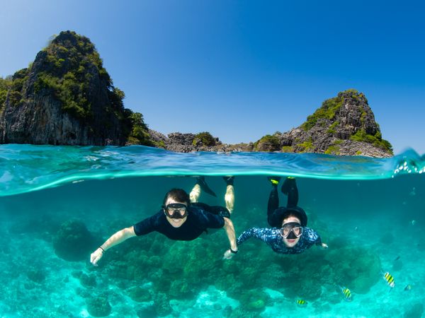 Couple snorkeling over-under split shot